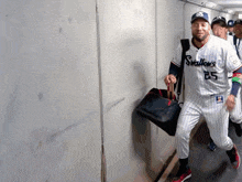 a man in a swallow 's baseball uniform is carrying a bag