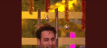 a man standing in front of a fence with christmas decorations hanging from it .