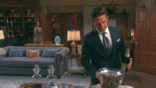 a man in a suit holds a bottle of champagne