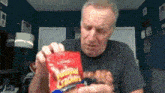 a man is looking at a bag of saltines crackers