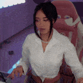 a woman in a white shirt is sitting in a pink chair with the letter g on it