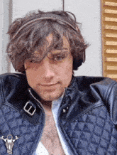 a man wearing headphones and a leather jacket with a zipper on his chest