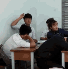 a group of students sit at desks in a classroom