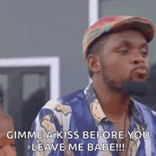 a man in a hat is saying gimme a kiss before you leave me babe !!