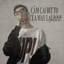 a man wearing glasses and a t-shirt with the letter up on it