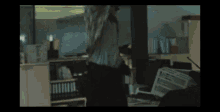 a man is being attacked by a zombie in a dark room in an office .