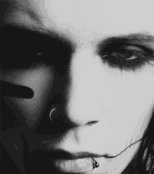 a close up of a person 's face with a nose ring and a lip piercing
