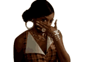 a woman is sitting in a chair wearing a plaid dress and a gold necklace .
