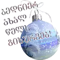 a blue christmas ornament with snow on it and the words " congratulations " in a foreign language