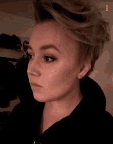 a close up of a woman 's face with a black shirt on