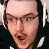 a close up of a man wearing headphones and glasses .