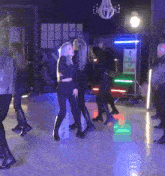 a group of people are dancing in a dark room with a sign that says the straight path of love