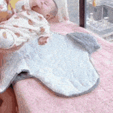 a baby is laying on a bed with a blanket that looks like a shark