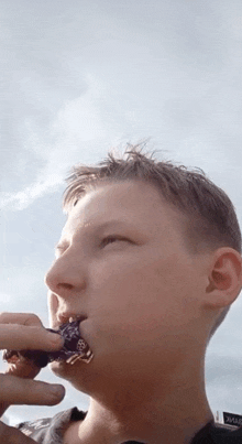 a young boy is eating a donut with a sign in the background that says ' aviaar '