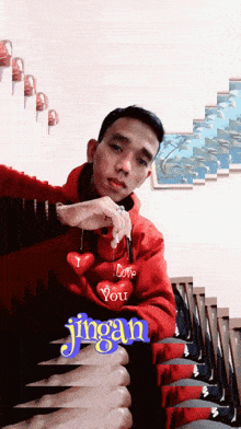 a man in a red jacket holding a heart with the word love on it