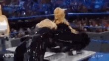 a wrestling match is being shown live on a television screen .