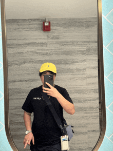 a person taking a selfie in front of a mirror with the word world written on their shirt