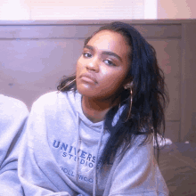 a woman wearing a grey sweatshirt that says universal studios hollywood