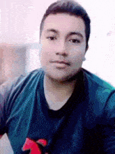 a man wearing a blue shirt with a red horse on the front