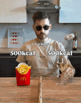 a man is sitting at a table with a mcdonald 's box and a glass of wine
