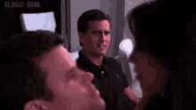 a man and a woman are talking to each other in a room . the man is looking at the woman .