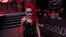 a woman with red hair is standing in front of a aw dark barrier