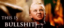 a man in a suit and tie is making a funny face with the words `` this is bullshit '' above him .