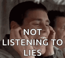 a man is covering his ears with his hands while talking on a phone .
