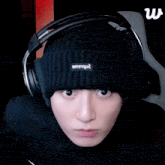 a person wearing headphones and a beanie that says enrique on it