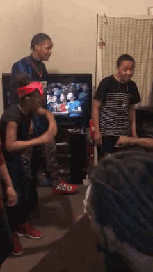 a group of young men are dancing in front of a tv with the number 218 on their feet
