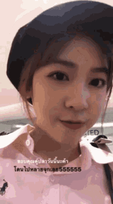 a woman wearing a black hat and a pink shirt with a polo on it
