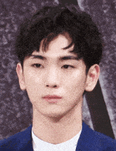 a close up of a young man 's face with a blue suit on