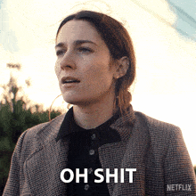 a woman in a plaid jacket is standing in front of a netflix logo