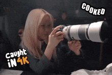 a woman taking a picture with a camera that says cooked on the bottom
