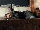 a woman is laying on a bed with pillows and a lamp