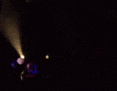 a group of people are standing on a stage under a spotlight