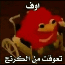 a red cartoon character is sitting in a wheelchair with arabic writing .