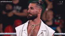 a man with a beard is wearing a gold chain around his neck with the letters s on it