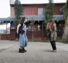 two women are standing on a sidewalk in front of a store