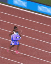 a group of women are running on a track with a purple robot in the middle