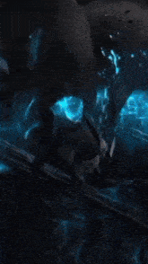a person is holding a blue light in their hand in the dark .