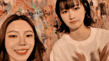 two girls are standing in front of a wall that has the word lucas + laila on it