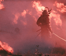 a samurai stands in front of a fire with a sword in his hand