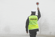 a police officer wearing a yellow vest that says policia