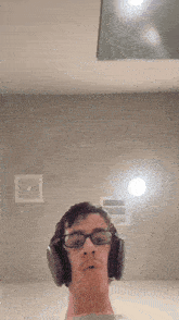 a man wearing glasses and headphones looks at the camera with his mouth open