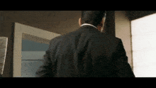 a man in a suit is walking out of a room