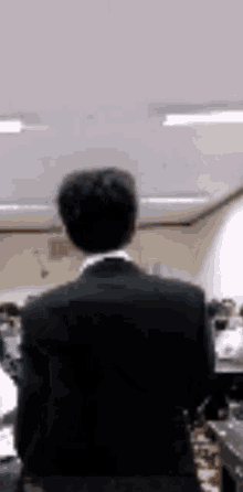 a man in a suit is standing in a classroom with a group of people .