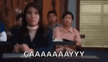 a woman is sitting in a courtroom with a group of people behind her .