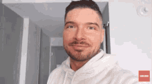 a man wearing a white hoodie with a red subscribe button