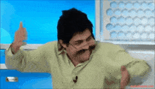 a man with a mustache and glasses giving a thumbs up